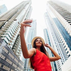 Uśmiechnięta influencerka robi selfie na tle gigantycznych wieżowców w Dubaju. Czy to rajskie życie jest tylko iluzją?